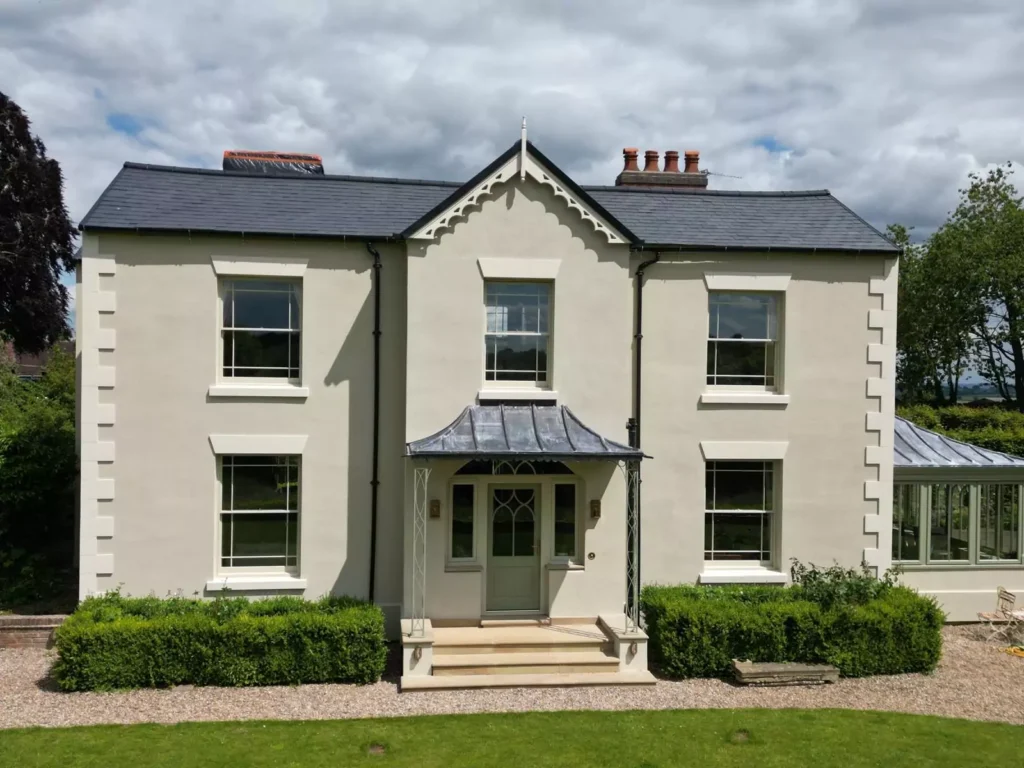 A newly built cream-plastered house featuring stone-coated quoins on the corners